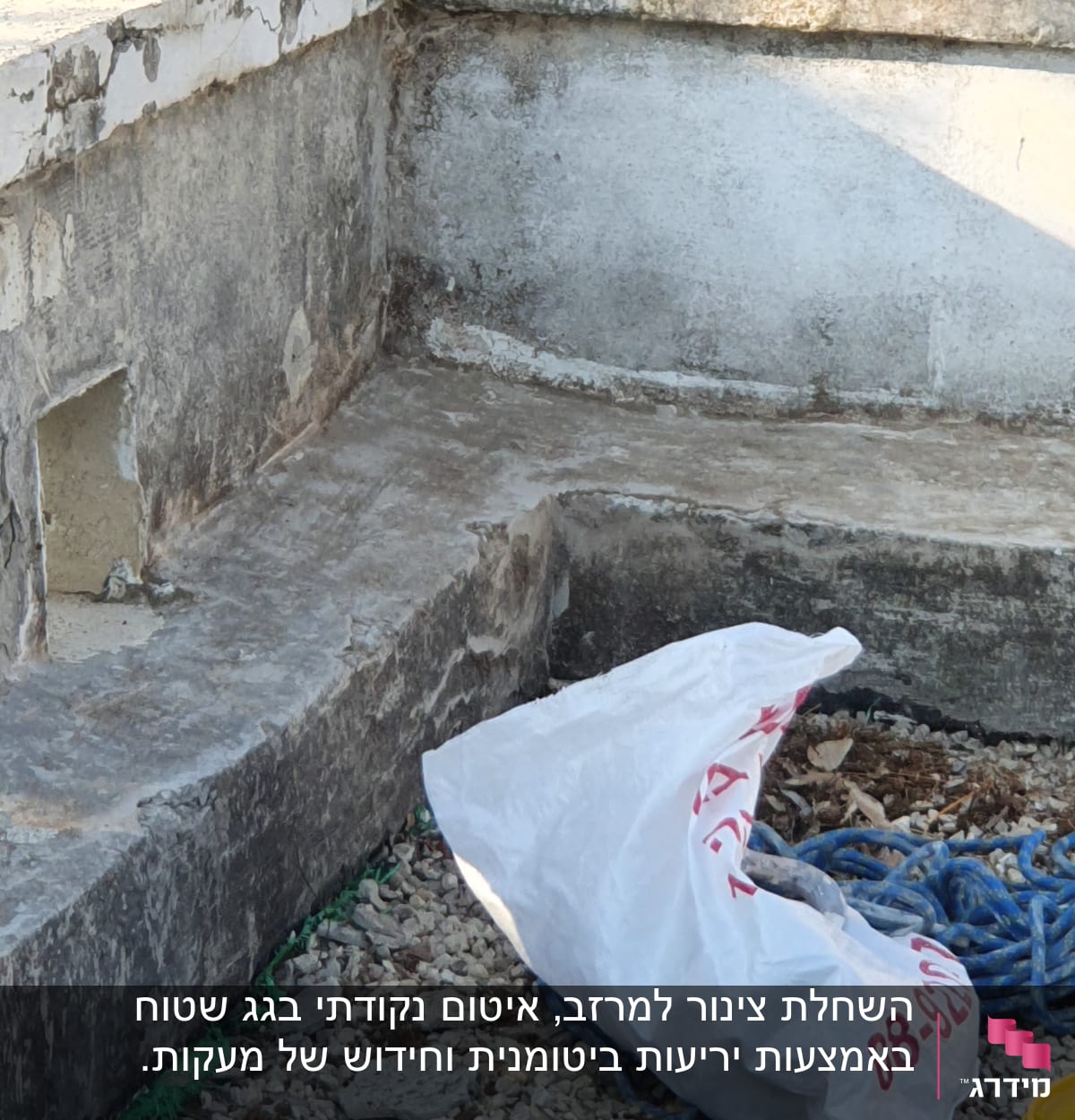 שקית פלסטיק וחבל כחול ליד קיר בטון